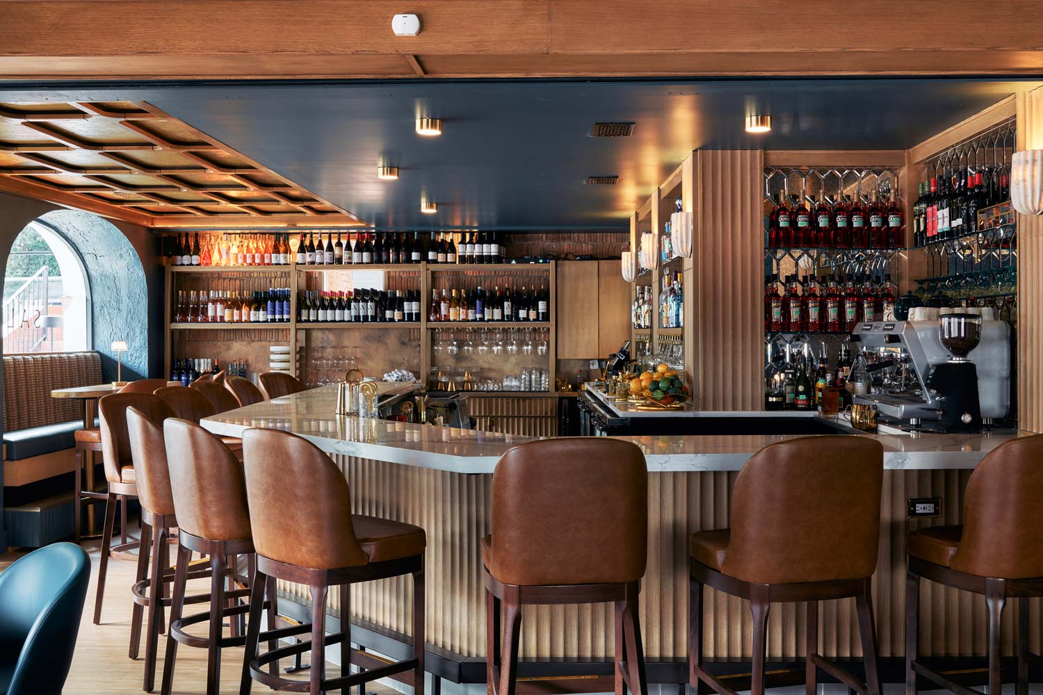 interior shot of restaurant bar with wood shelves full of wine