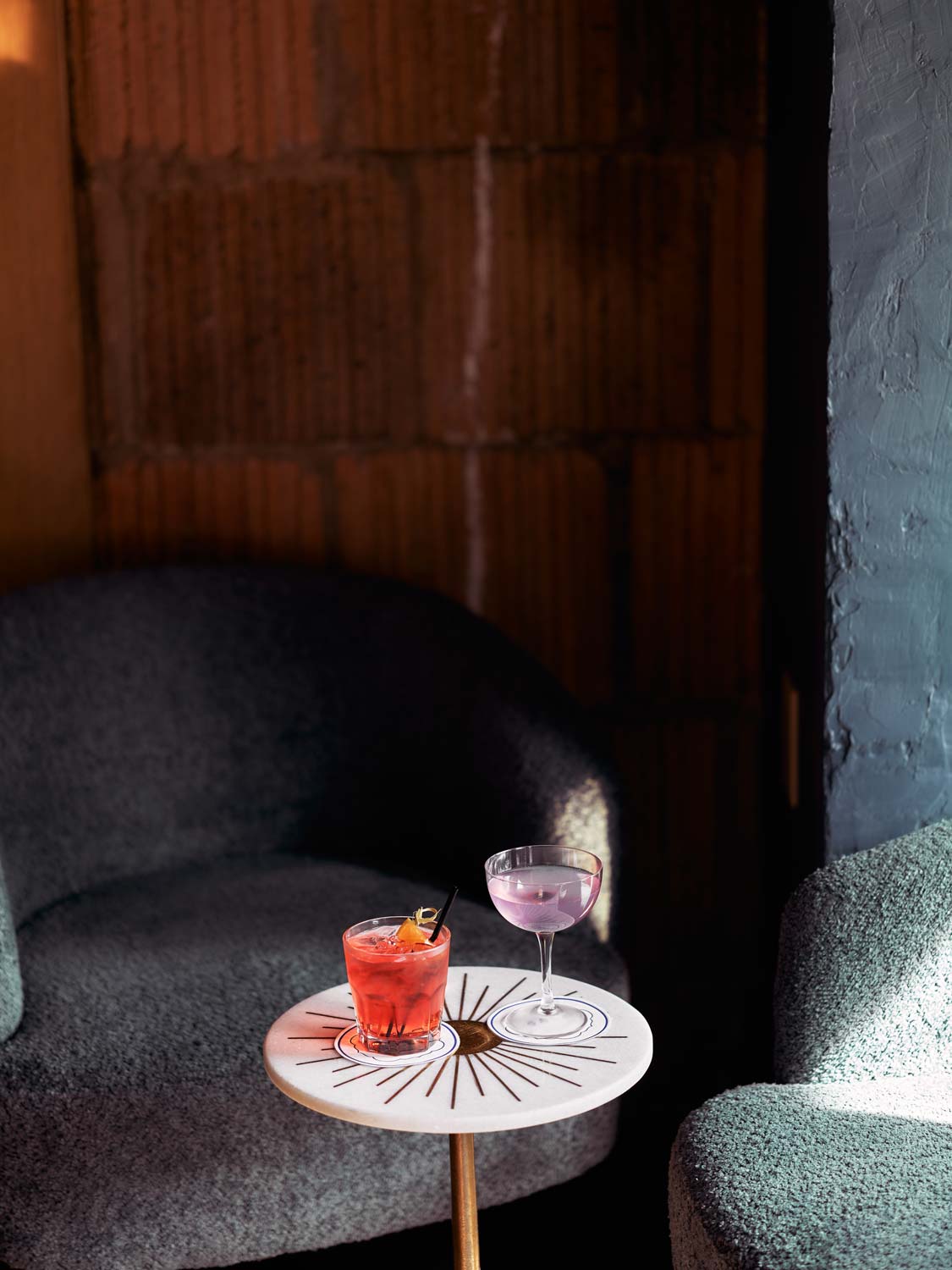 two cocktail glasses on a small restaurant table